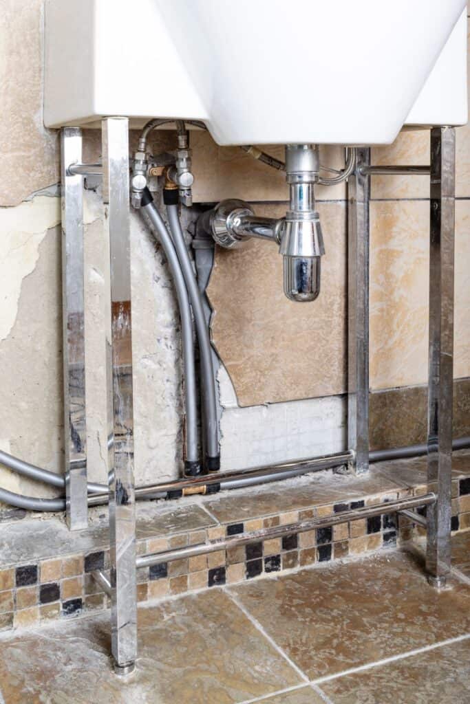 Professionel VVS-installation under håndvask med forkromet vandlås