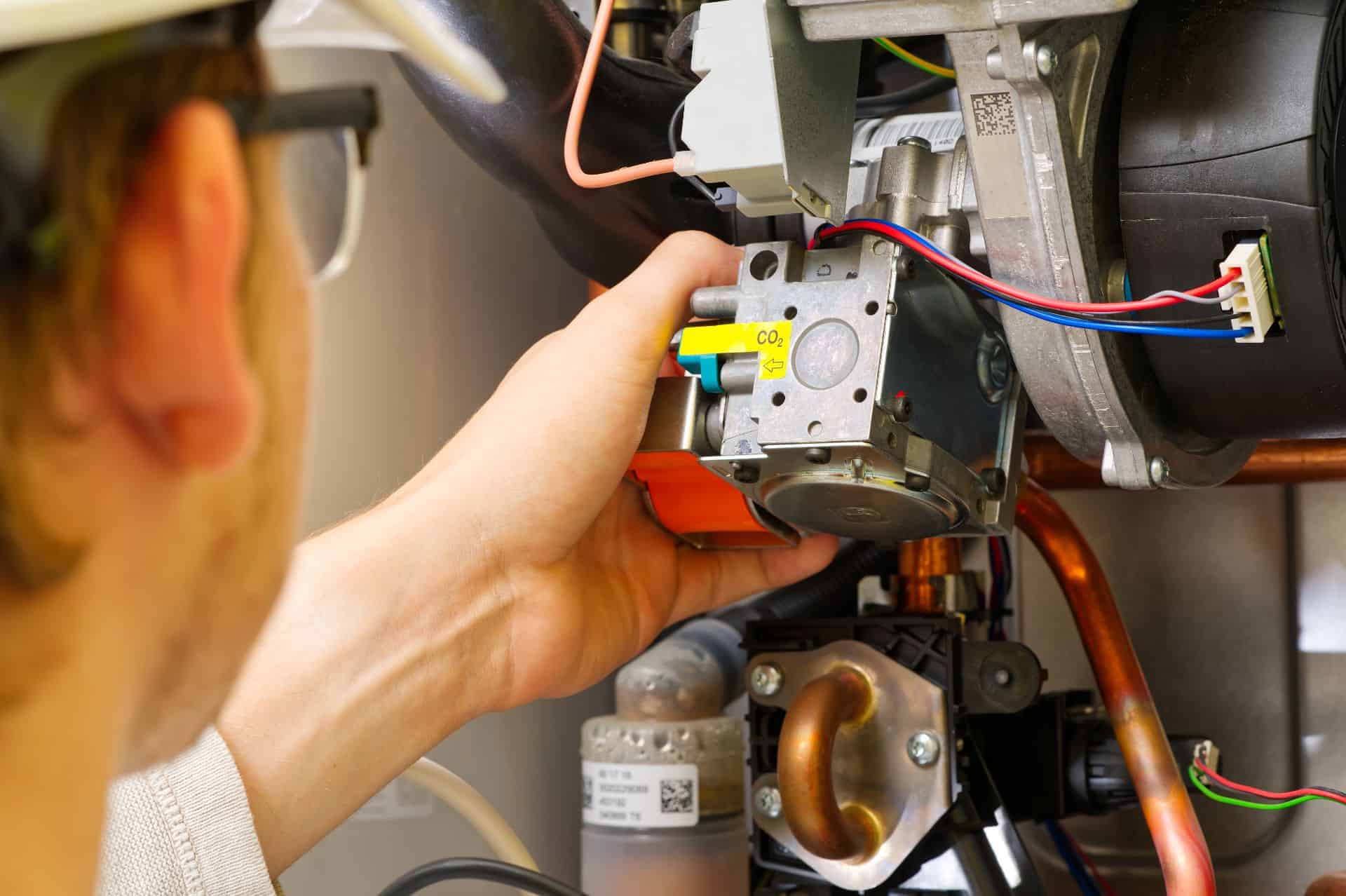 En erfaren VVS-tekniker fra Mankov VVS udfører præcis installation af et moderne gasfyr